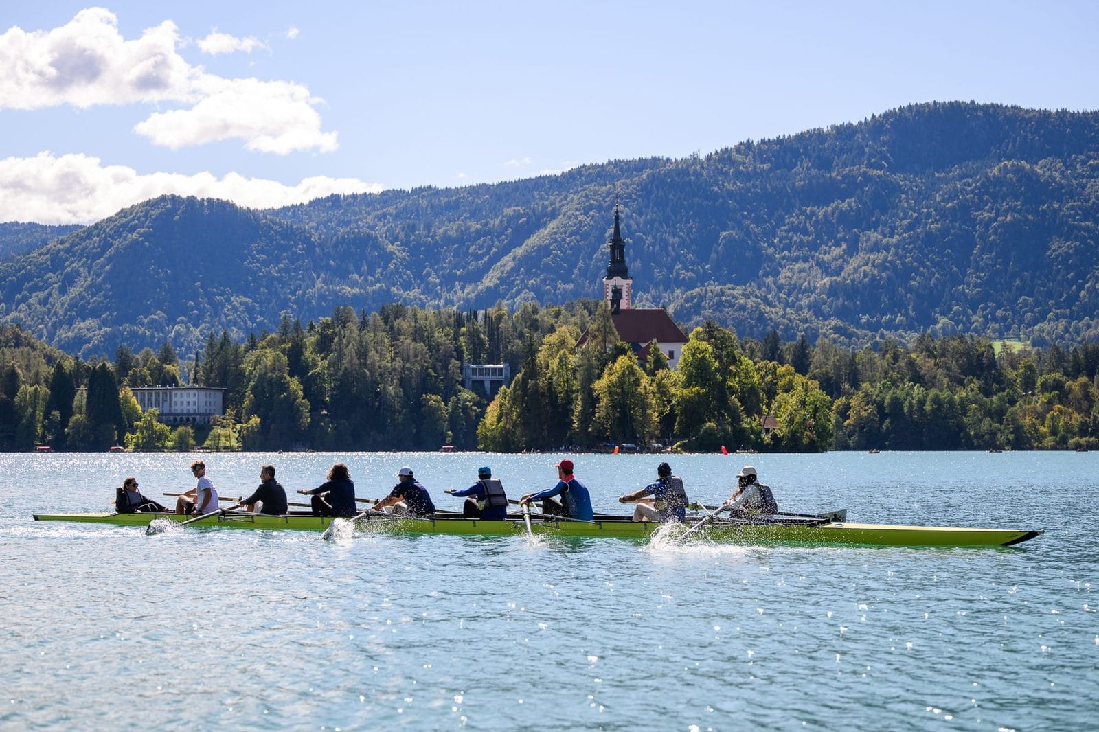 A group rowing on Lake Bled with the island church behind